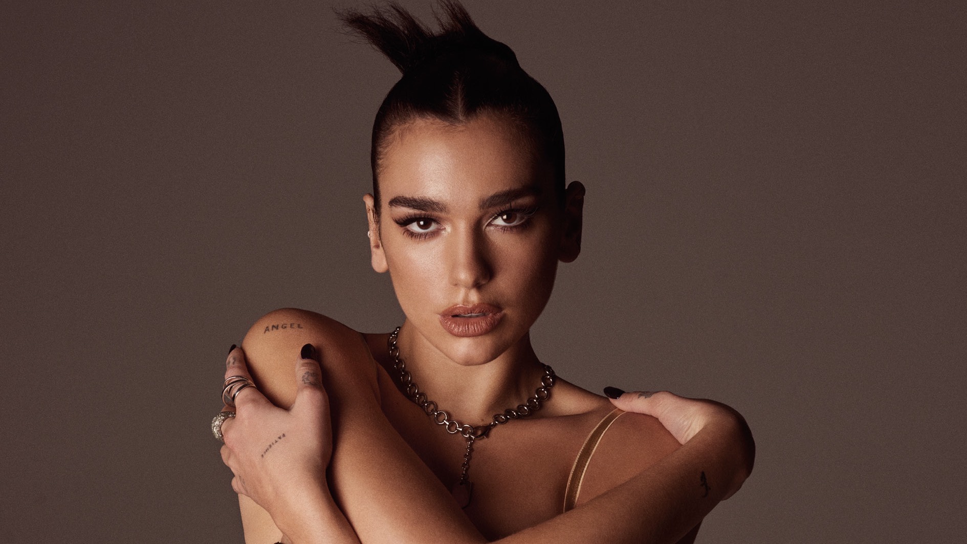 Did with hair up in a bra top with arms wrapped around herself