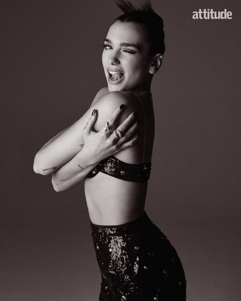 dua lipa winking, in a black sequinned bra and trousers