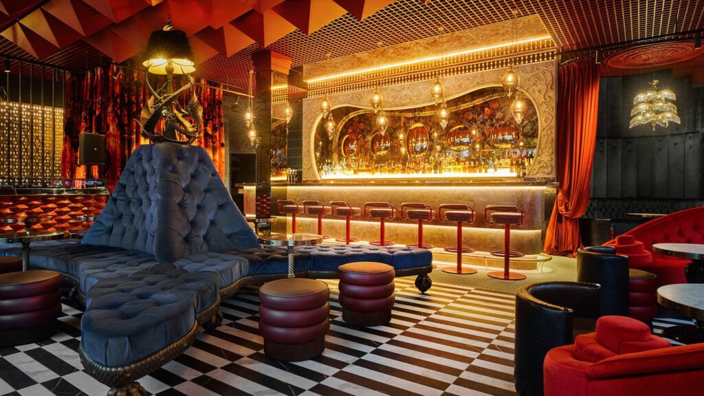 A brightly lit bar with lots of gold and plush furniture surrounding it