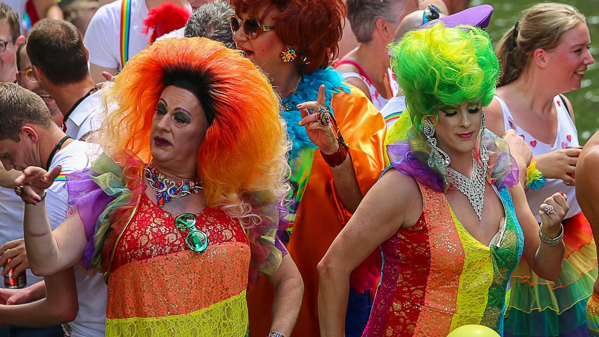 Two drag queens and other party-goers dancing at a Pride party