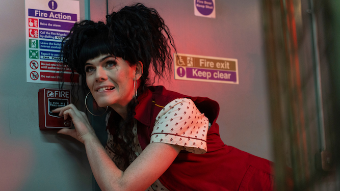 Jordan Gray in character setting off a fire alarm in the show