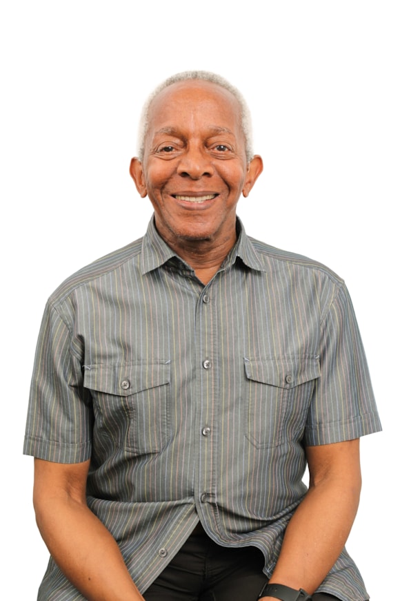 A smiling man in a striped short looks into the camera