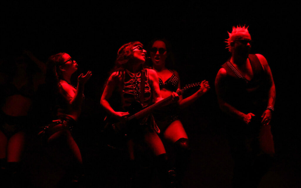 Lady Gaga dancing with backing dancers in red lighting