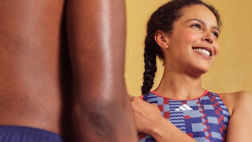 Two people holding hands, one smiling and looking away