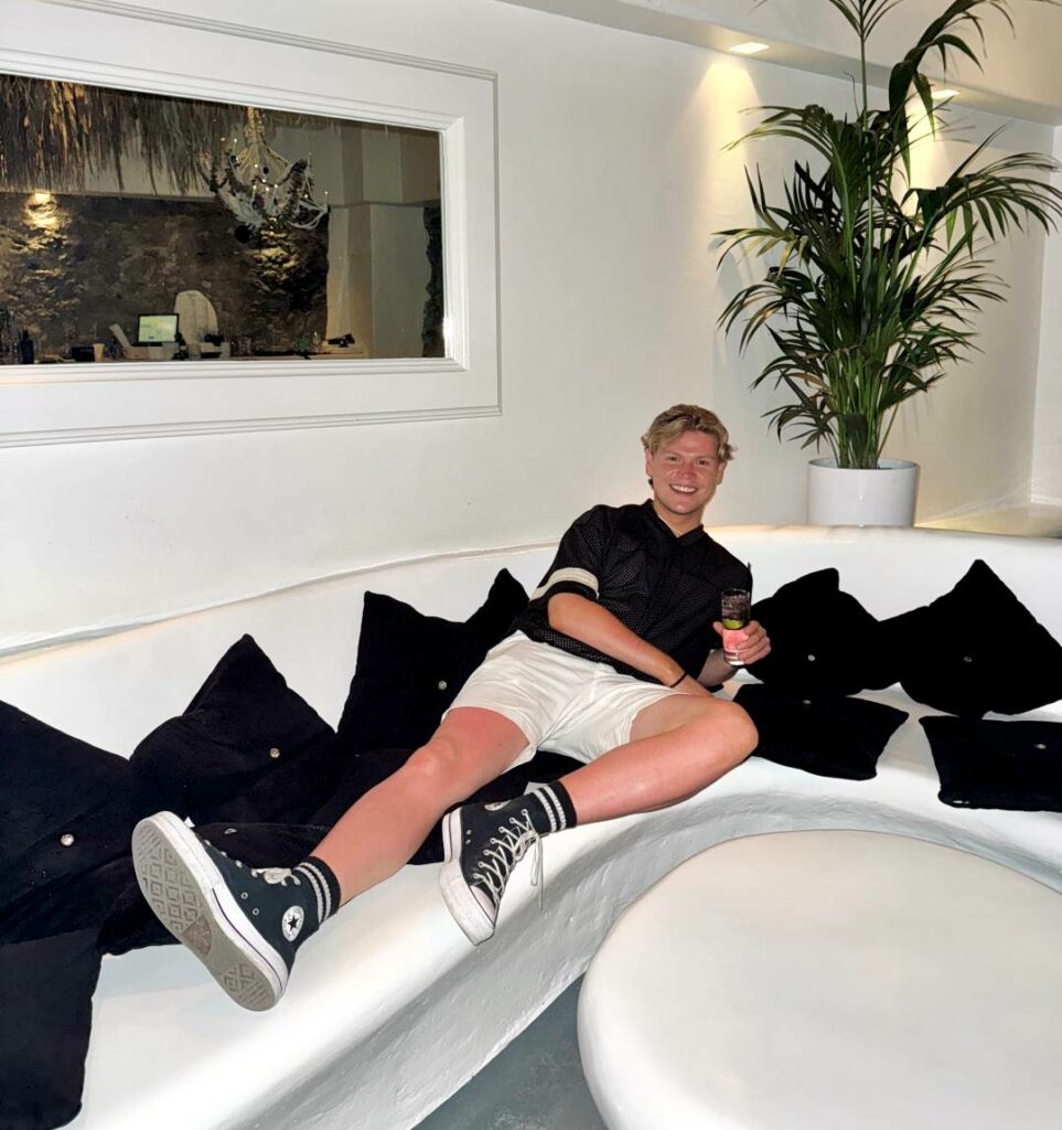 A man in shorts and T-shirt relaxing on a white sofa