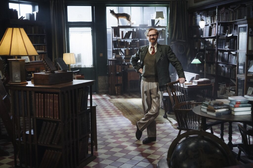 Gatiss in character in book store, with stuffed fox in windowsill