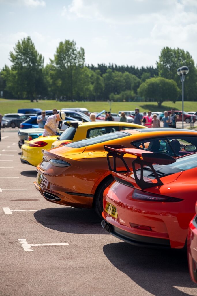 A gradient of orange hued cars lines up 