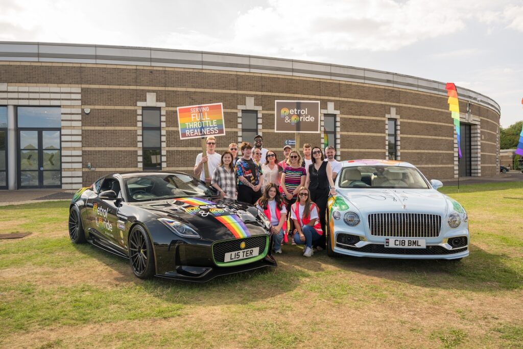 Petrol & Pride team next to two cars with rainbow art printed across them. 