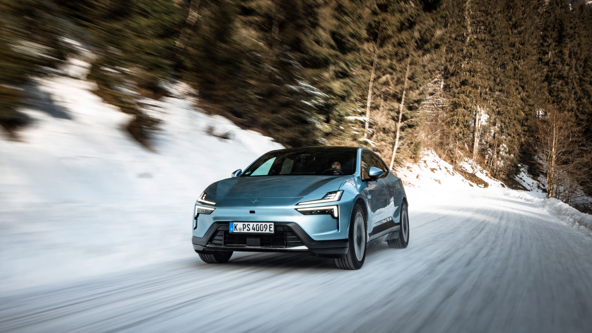 Polestar 4 in a teal blue driving through the snow