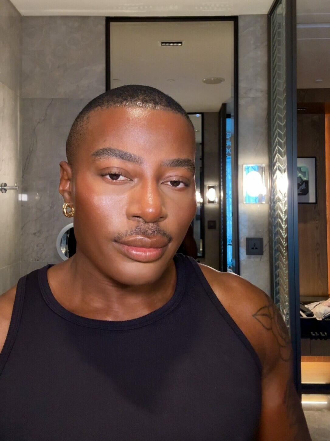 Gary Thompson in his bathroom wearing gold earrings and his "blonzing" look