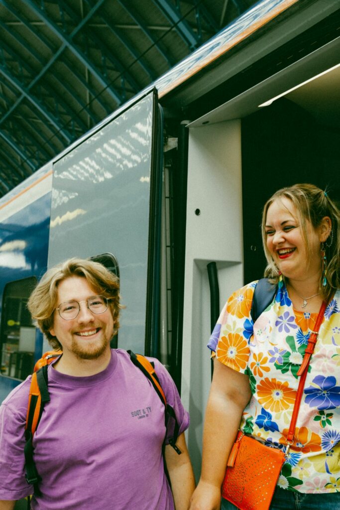 Two smiling people in front of a Eurostar train