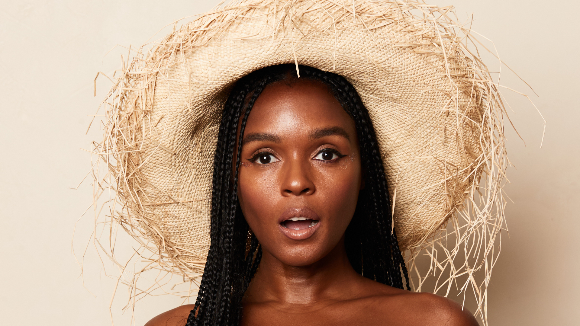 Janelle Monae wearing a straw hat