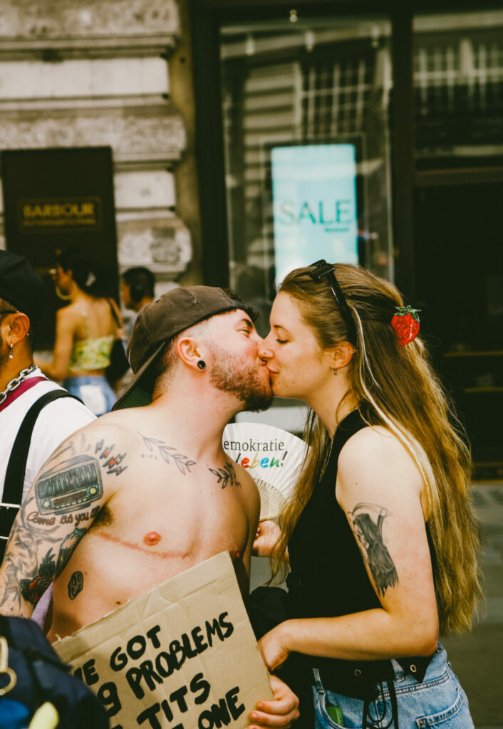 A transgender man kissing a woman in a display of love and unity.