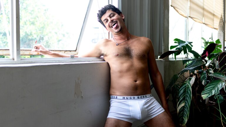 Alfonso T in the new issue of Elska - standing by a window in white underwear, green plant visible behind