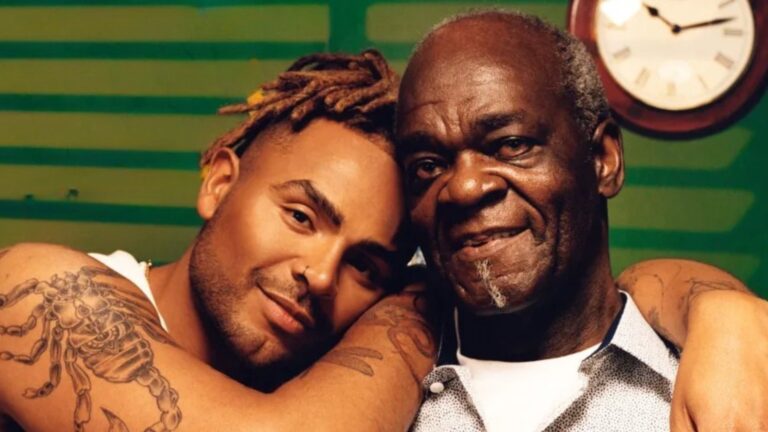 Nathan Henry embracing his father, green background with a clock visible
