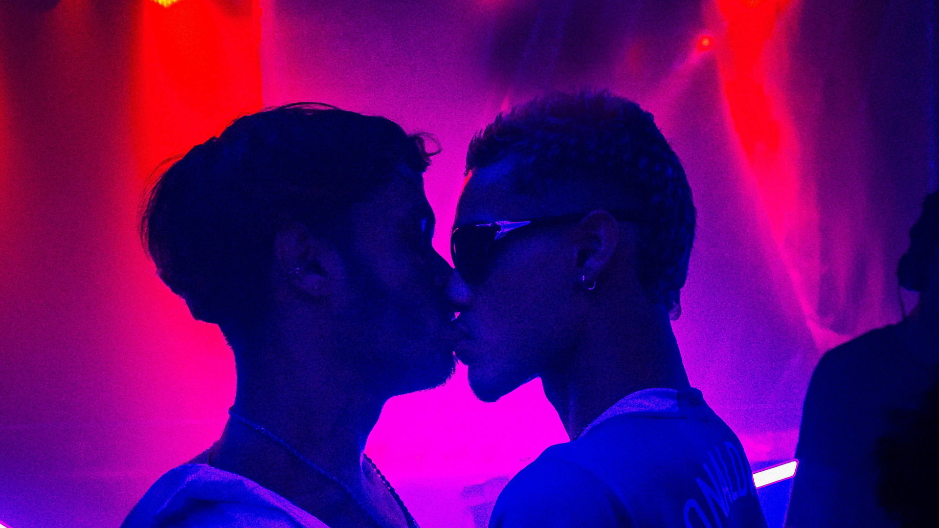2 men kissing in a club