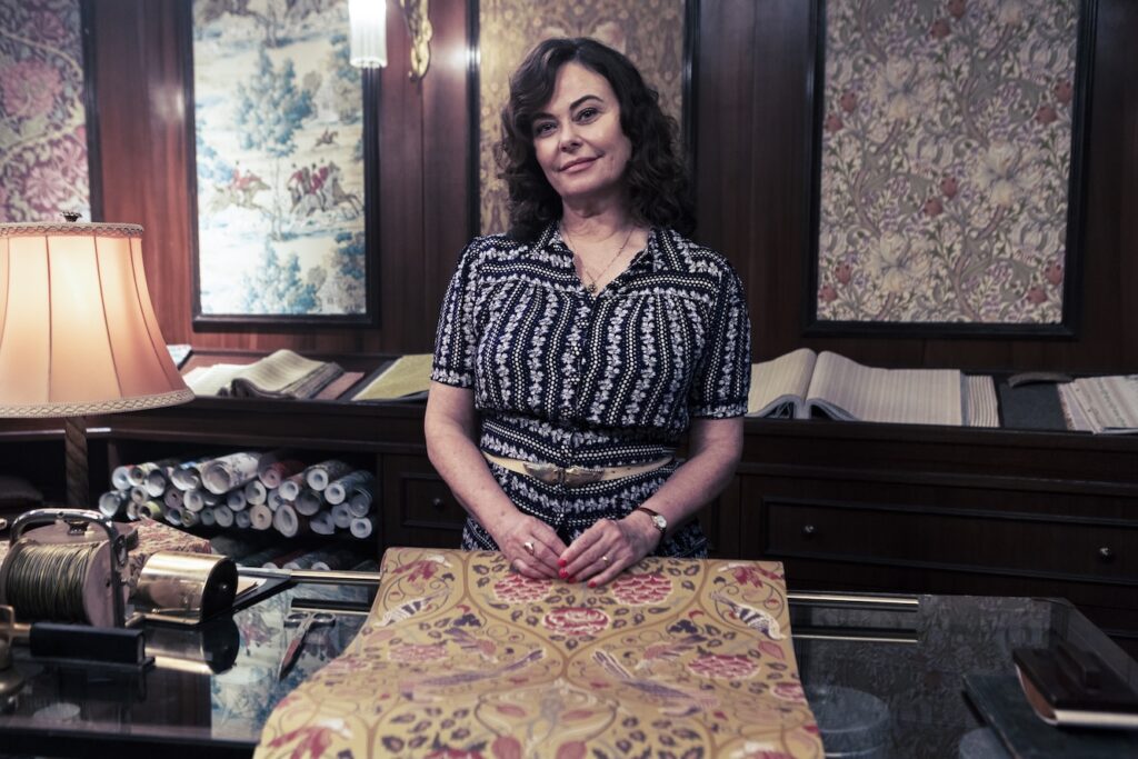 polly in character working as a seamstress