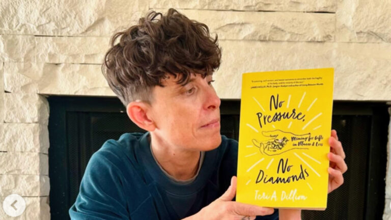 Andrea Gibson holding up her book