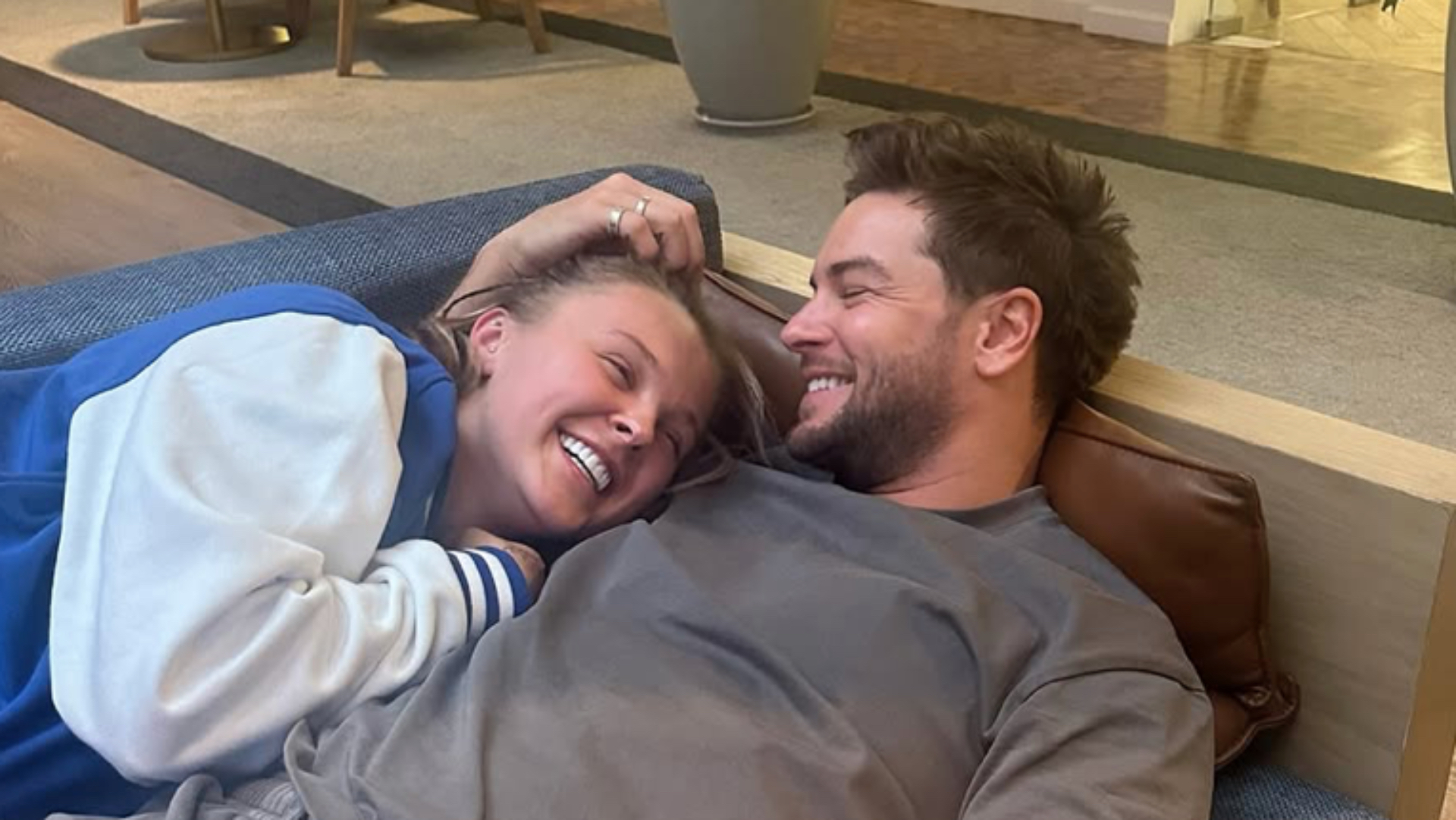 JoJo Siwa and Chris Hughes cuddled up on a sofa