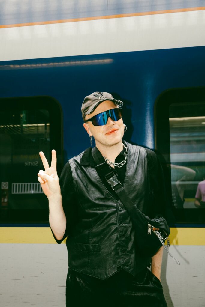 A smiling prson in a black jacket standing in front of a Eurostar train