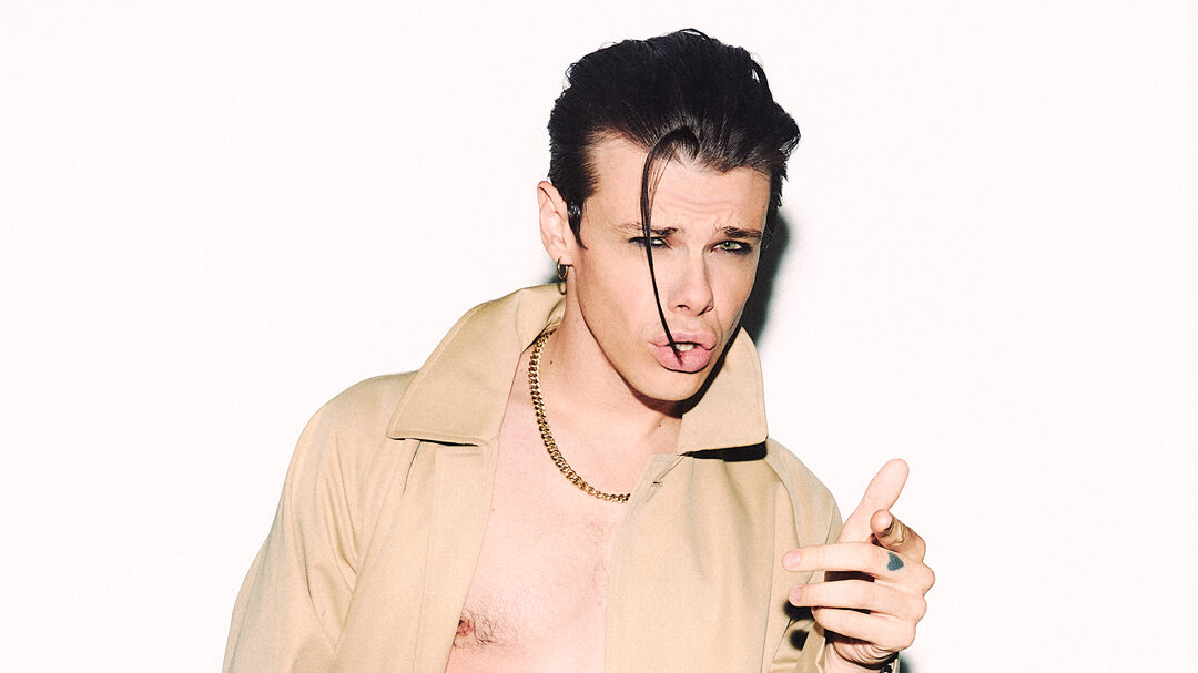 Yungblud in a tan coat open against white backdrop (Image: Tom Pallant)