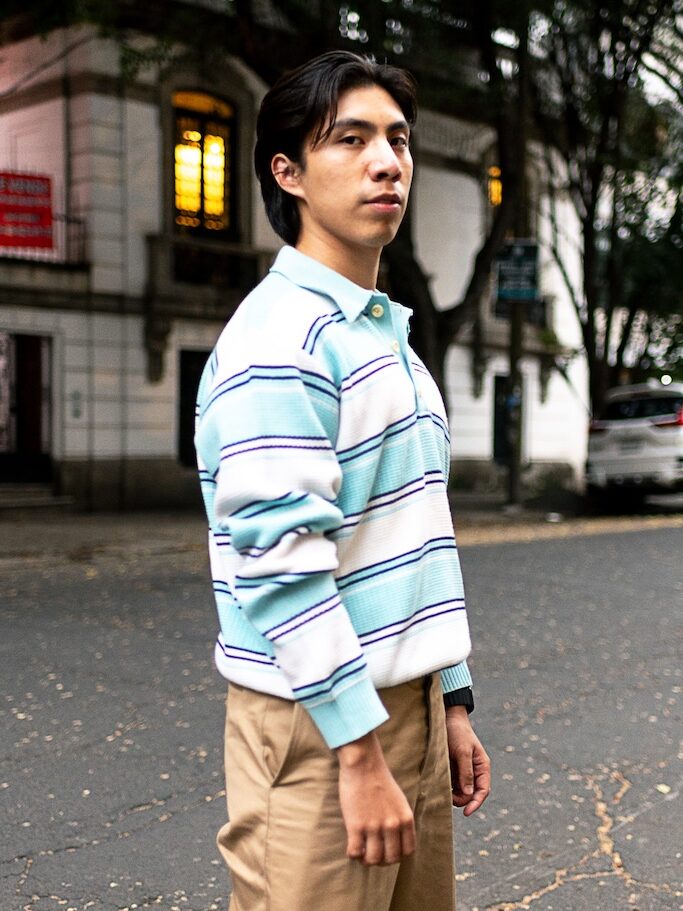 Ray M in blue stripy jersey, standing in street