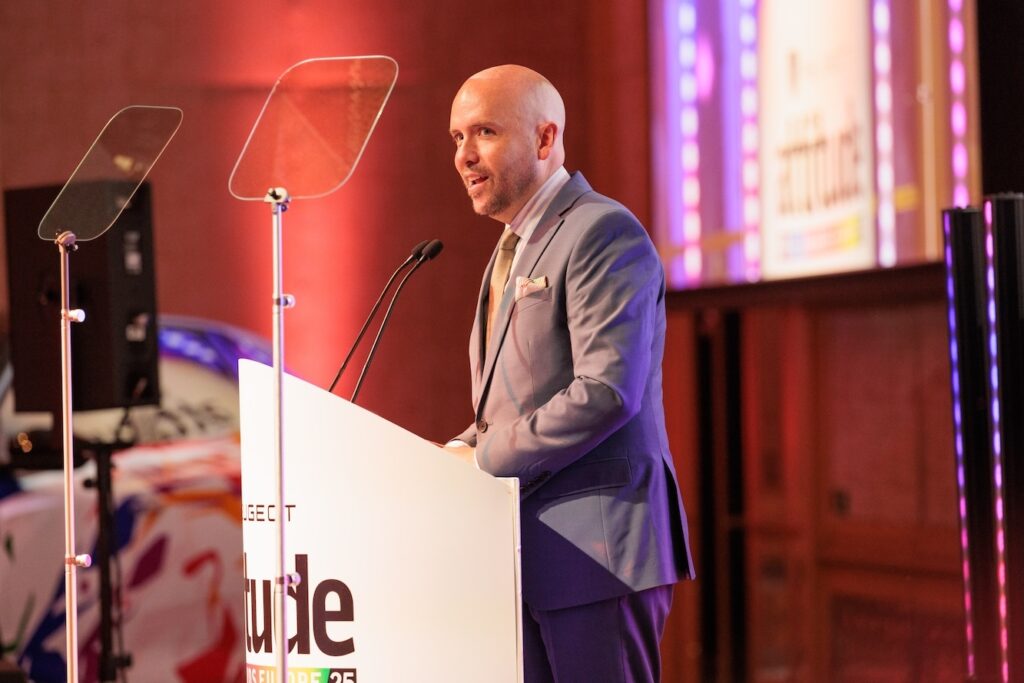 tom Allen standing on the podium addressing the room