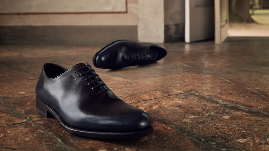 A close-up of black polished leather men's Ferragamo shoes in the brand's autumn/winter 2025 campaign.