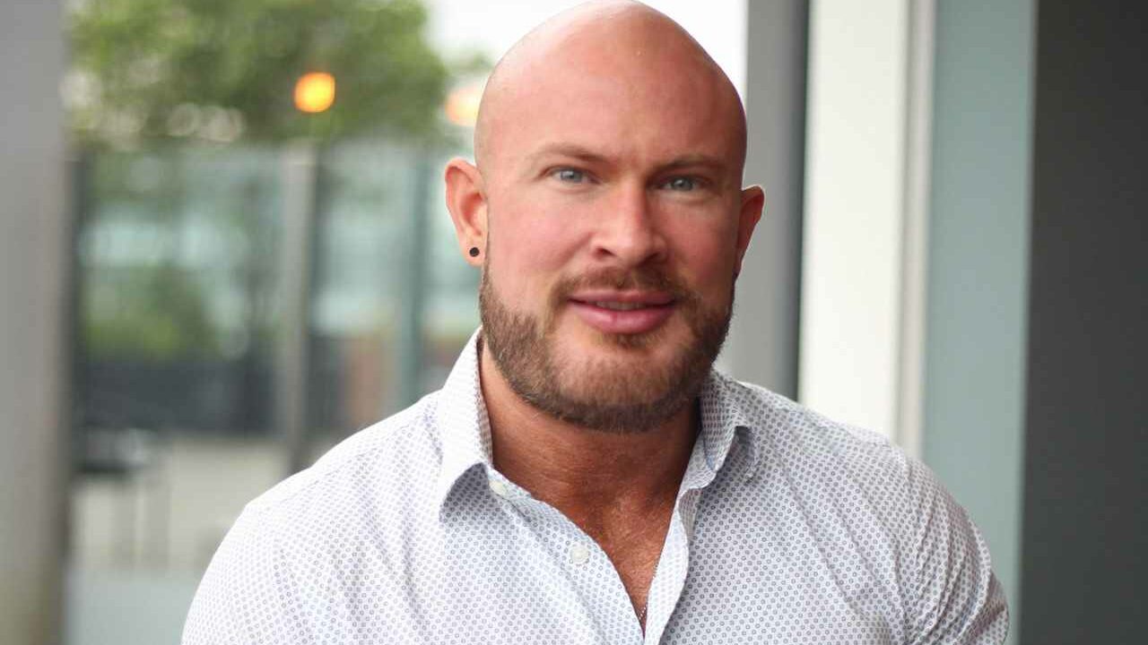 A smiling man wearing a white shirt