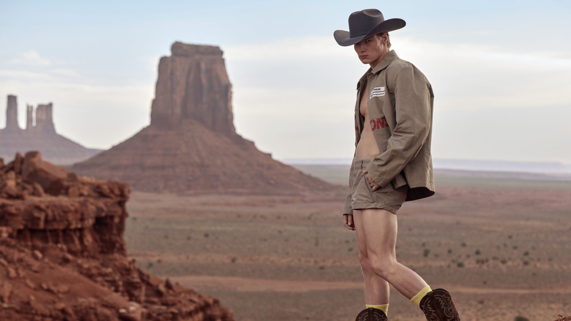 Cowboy wearing Snow Goose by Haider Ackermann S/S 25 shirt and shorts against the Utah desert background.
