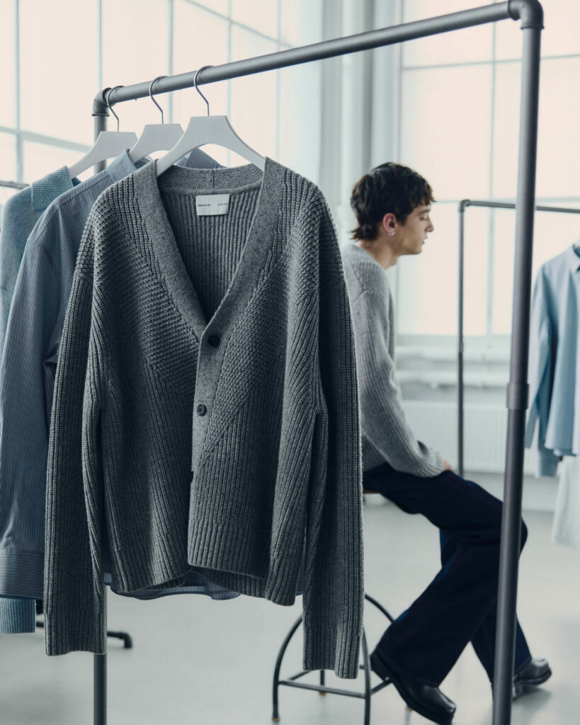 A rail of clothes in a sunlit studio showcases a great knit cardigan from the H&M Atelier pre-fall 2025 collection.