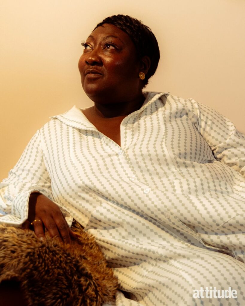 Lady Phyll reclining on a sofa looking away from the camera, wearing a white dress