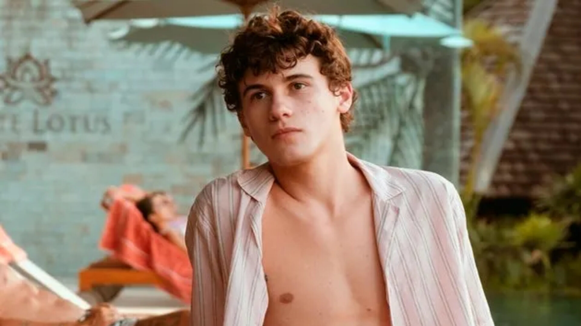 Sam Nivola in an unbuttoned striped shirt