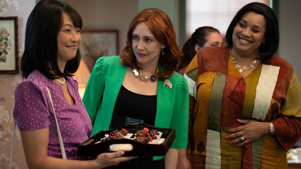 Joy Osmanski as Setsuko McAffey in a purple top and Vera Farmiga as Barb Cope in a green jacket stood in a room (Image: Netflix)