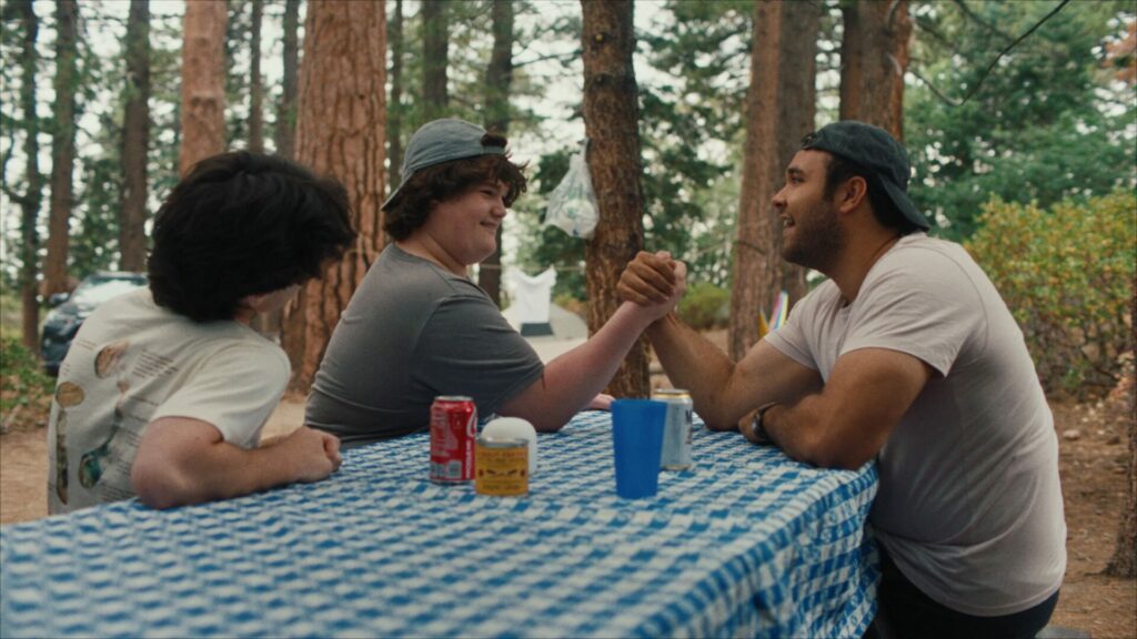 Isaac Krasner and David Johnson III on a picnic bench arm wrestling 