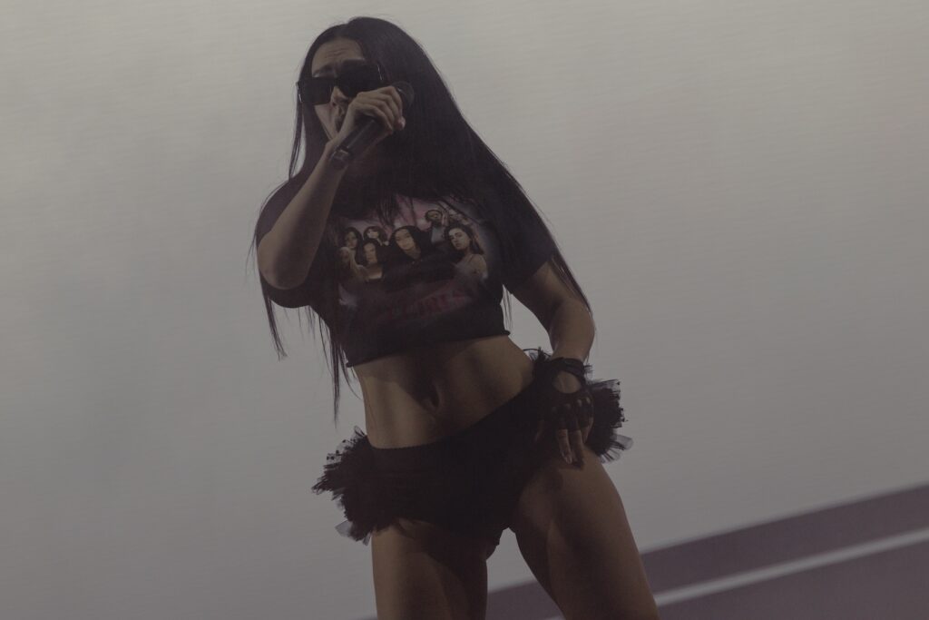 charli on stage in sunglasses and black t-shirt
