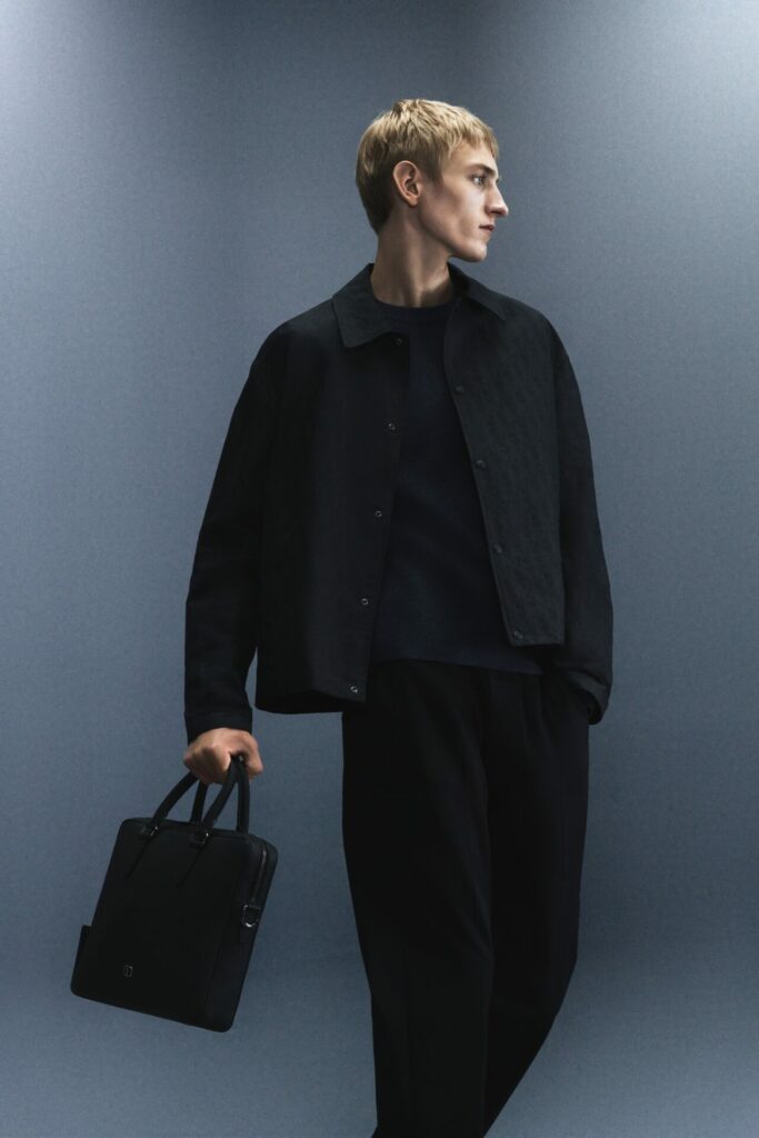 Model in all black over shirt, jumper and loose trousers for the Dior Men's "Back in Town" capsule collection