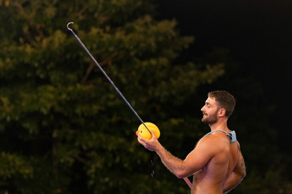 Topless man playing with a fishing rod