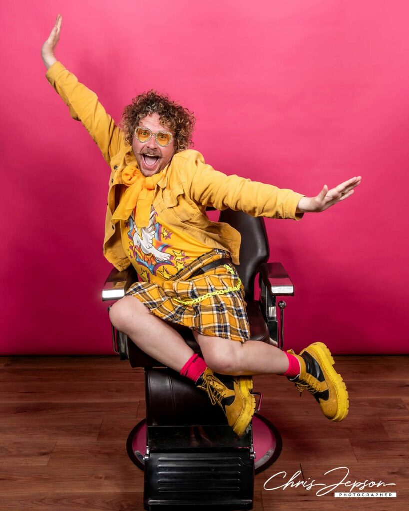 A person wearing yellow sitting in a barber's chair