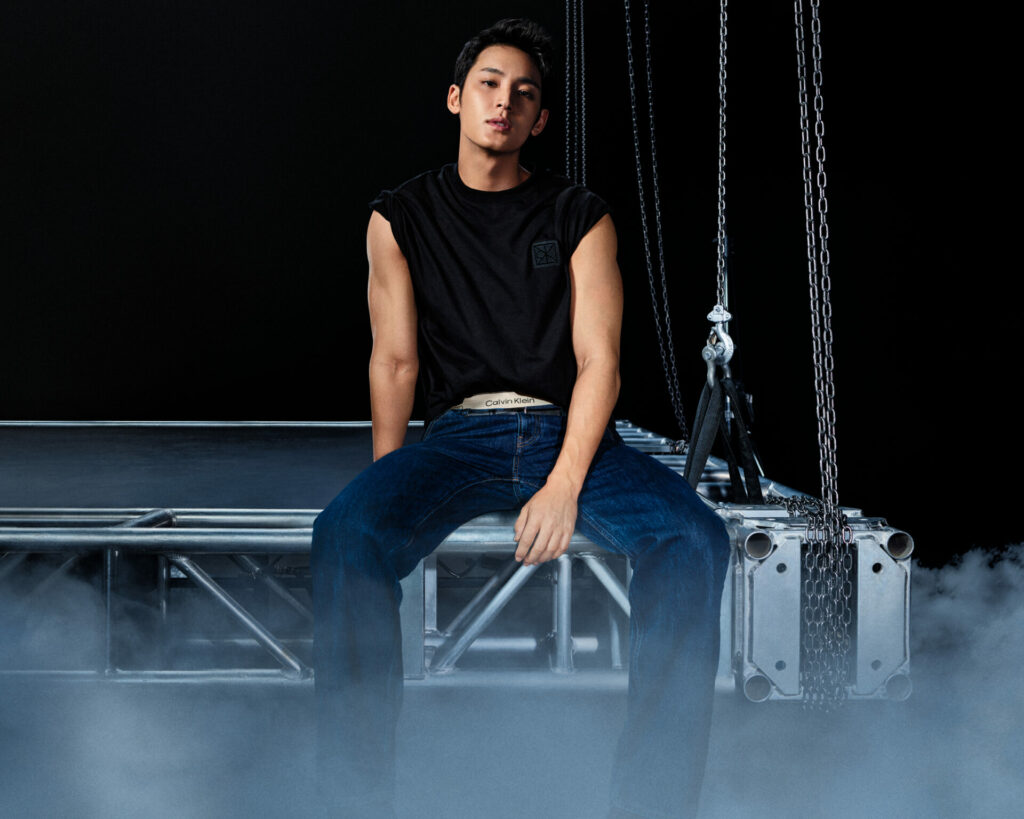 Mingyu for Calvin Klein fall 2025 denim. K-pop star Mingyu wears a black sleeveless tee with blue denim jeans revealing his Calvin Klein logo underwear.