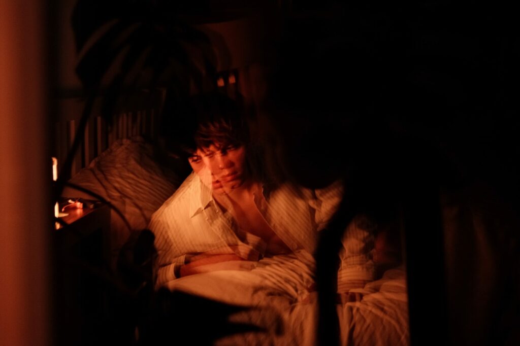 Fred Roberts in a distorted image of him leaning on his bed