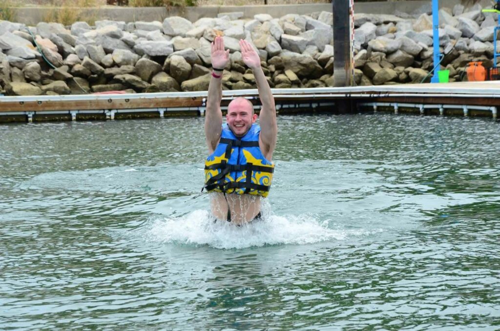 A man in a pool of water wearing a life vest