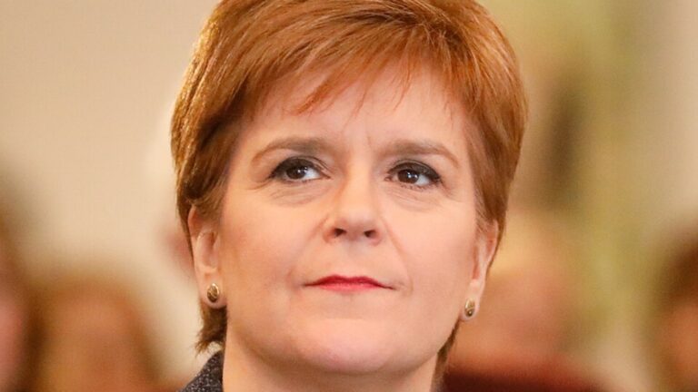 Nicola Sturgeon headshot looking to the top left of the screen in bright pink lipstick