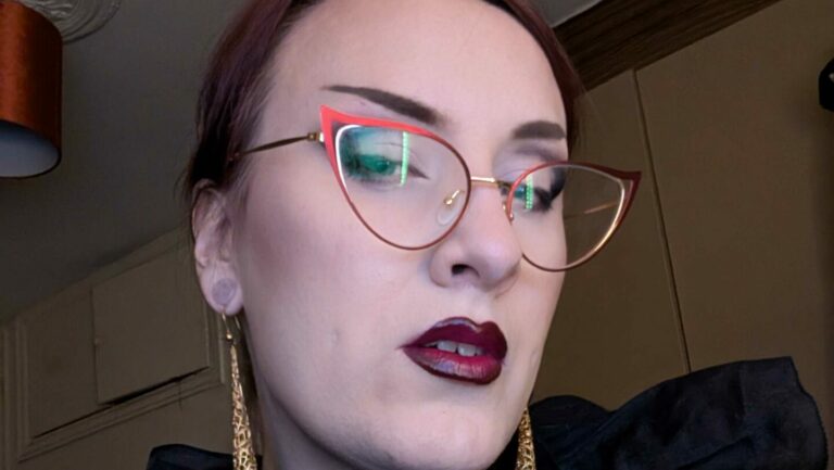 Close crop of a smiling woman's face wearing glasses