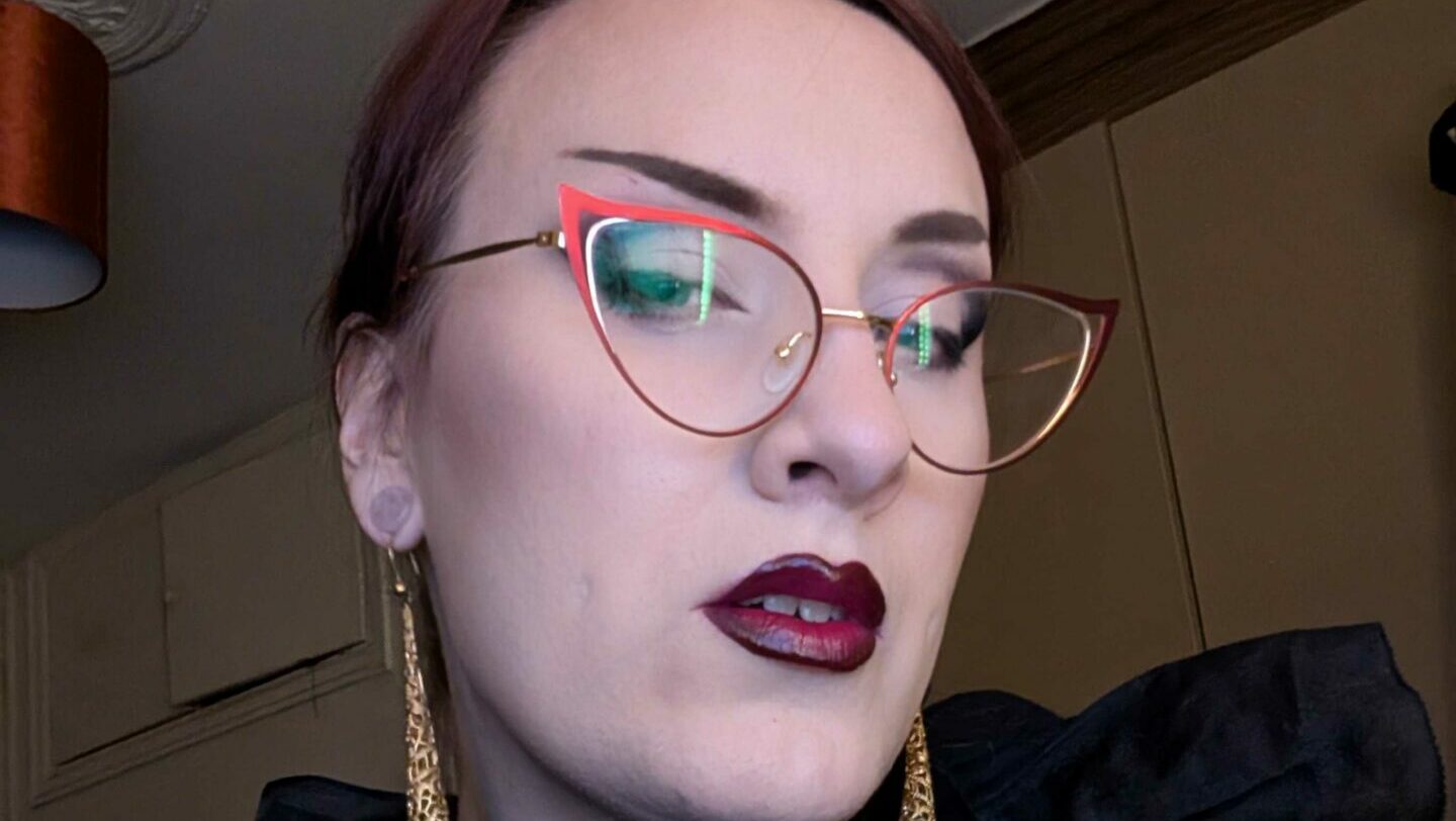 Close crop of a smiling woman's face wearing glasses