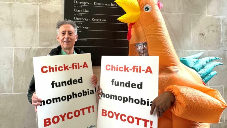 Peter Tatchell and a person in a chicken costume holding protest signs