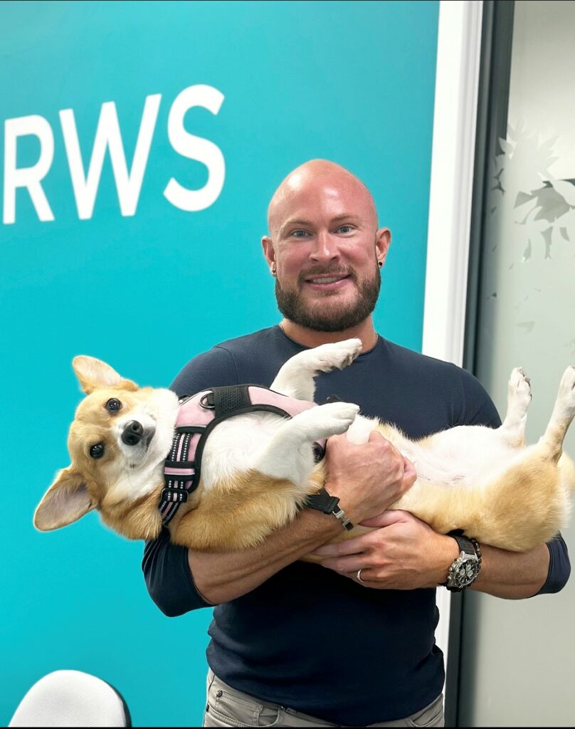 A man holding a corgi