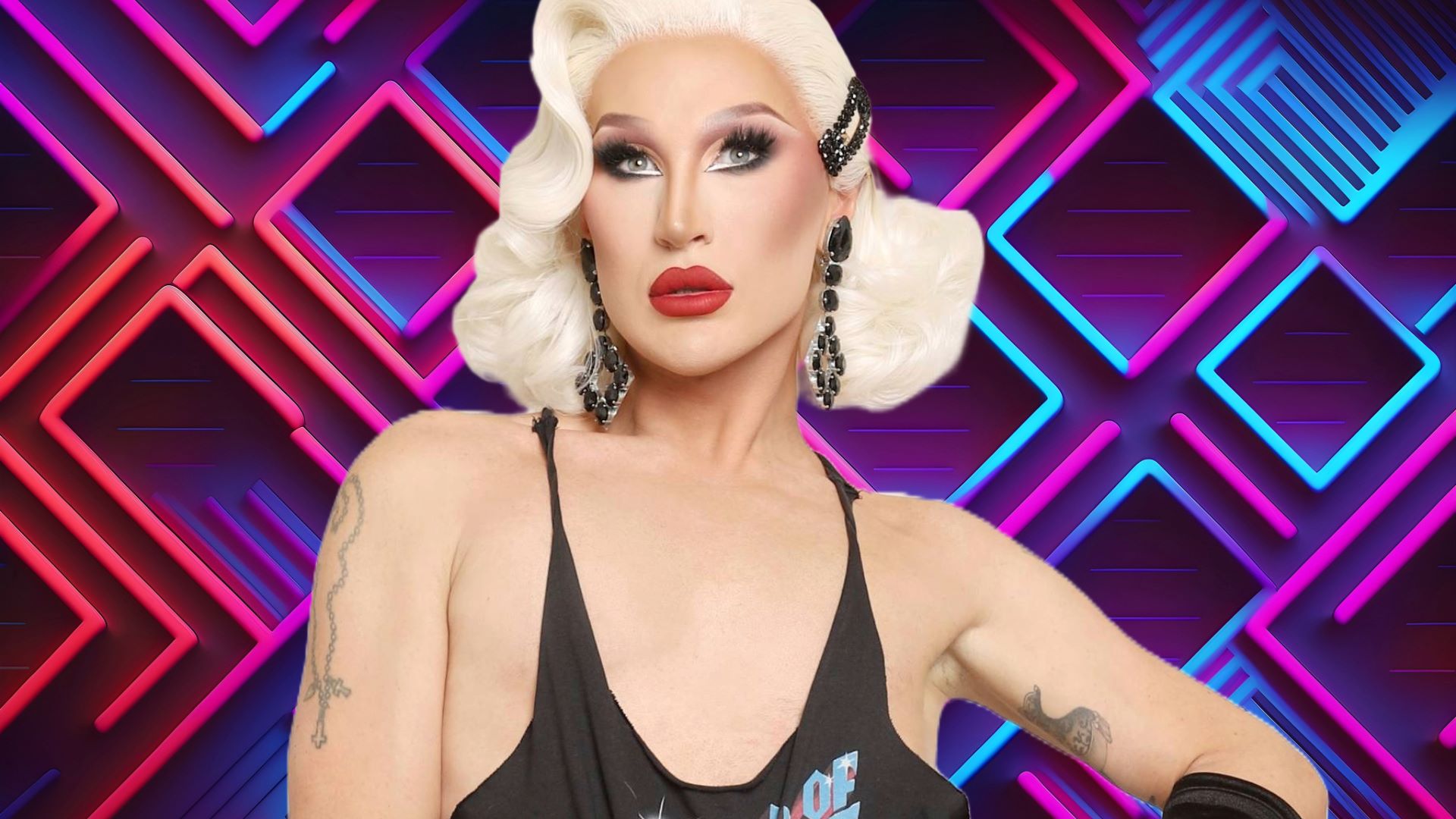 The Vivienne wearing a black vest top and wearing blond hair against a colourful backdrop