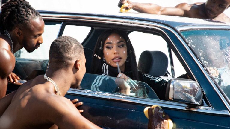 BombayMami in the video for new track 'Hot Boyz' sitting in a car with shirtless men around her
