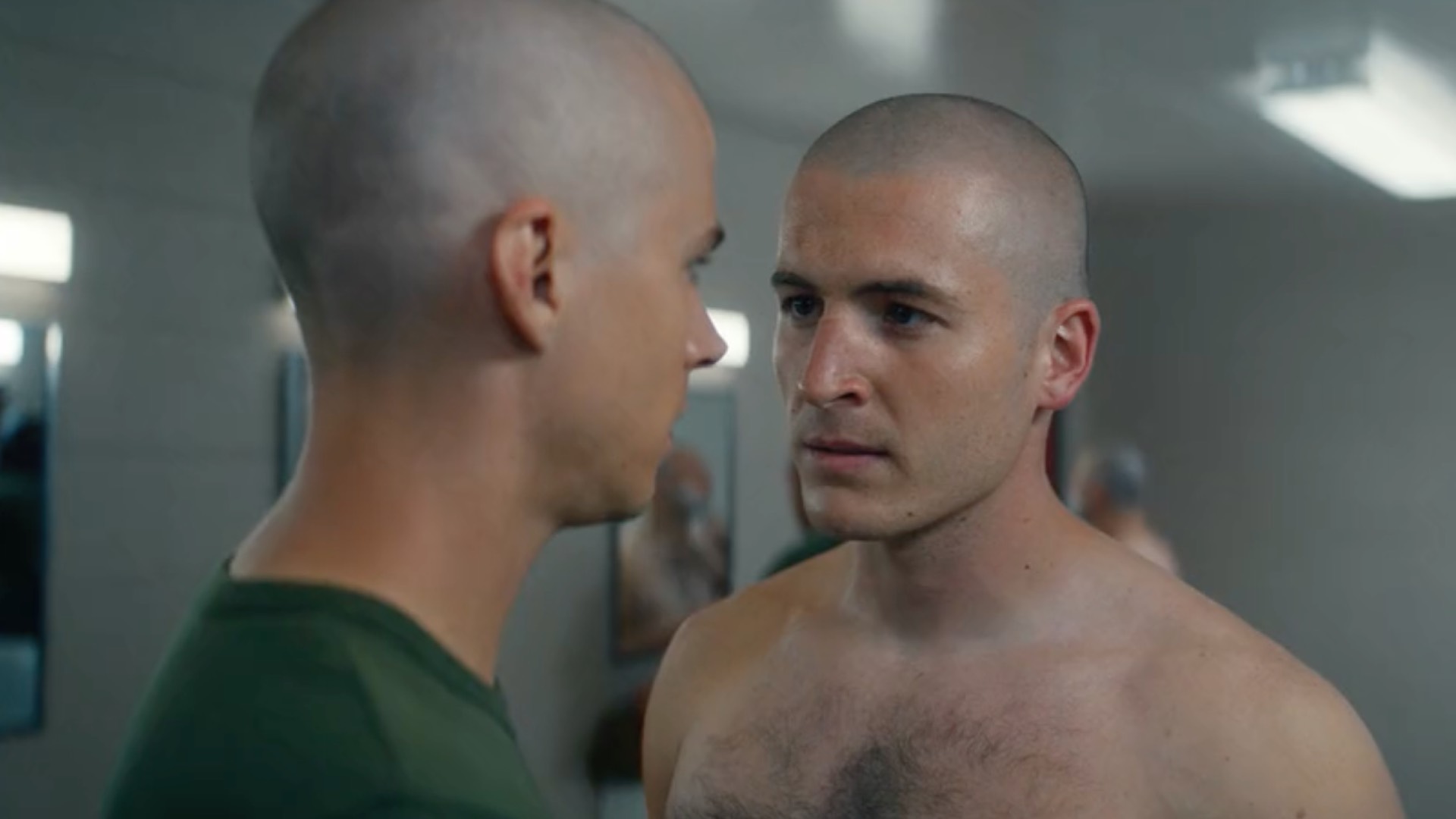 Miles Heizer (left) as Cameron and a topless Kieron Moore as Slovacek, in the boot camp changing rooms, talking (Image: Netflix)